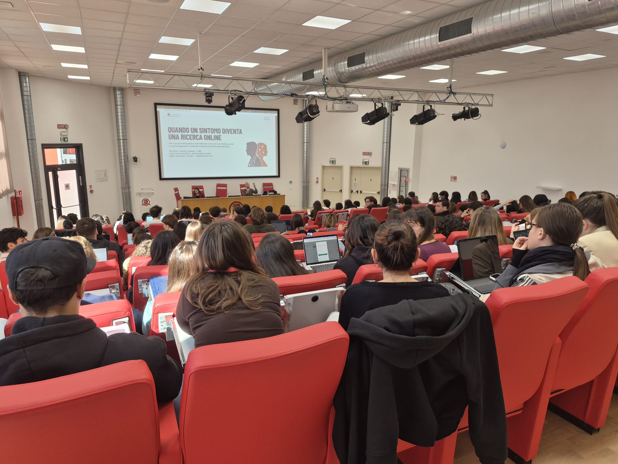 Partecipanti durante una presentazione a UNICAMILLUS